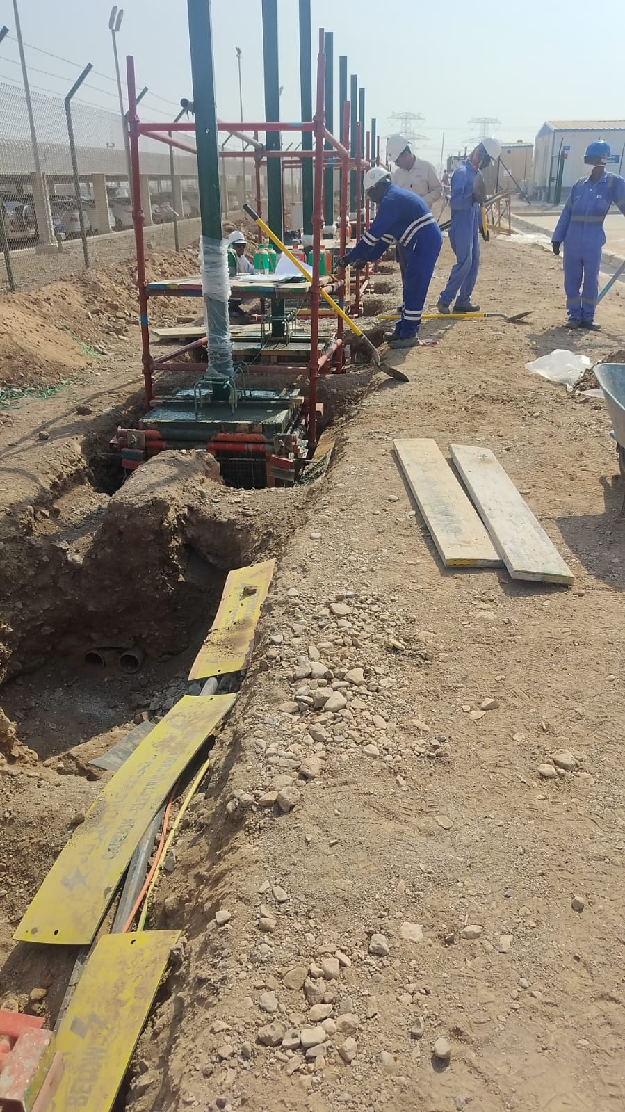 Oil well hook-up and flowline installation in desert field.